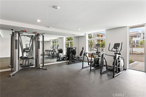 Indoor gym area with exercise equipment and large windows.