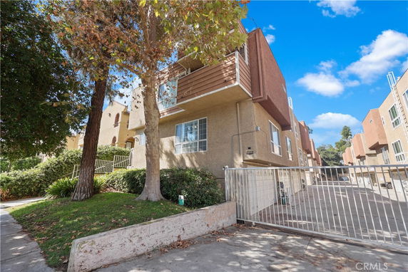 Front view of a multi-story residential building with a gated entrance.