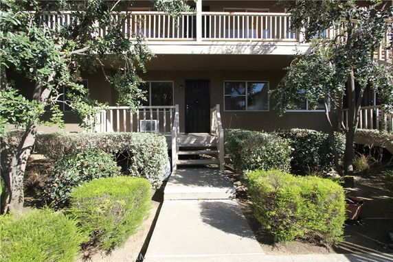 Front view of a house with a porch and surrounding greenery.