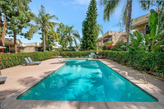 Outdoor swimming pool surrounded by greenery and residential buildings