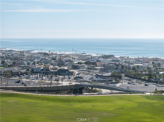 Wide angle view of a coastal town with buildings and the ocean in the background.