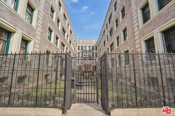 Front view of a multi-story building with a gated entrance.