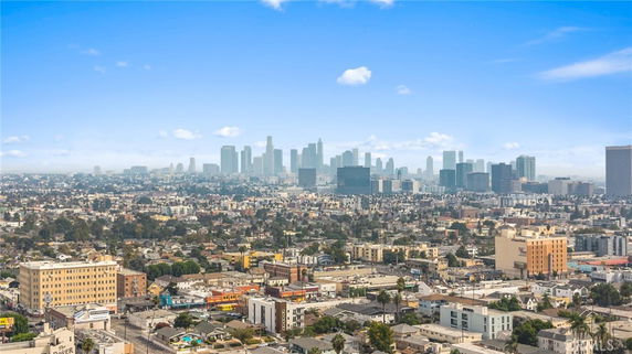 Panoramic view of a city skyline with numerous buildings under a clear blue sky.