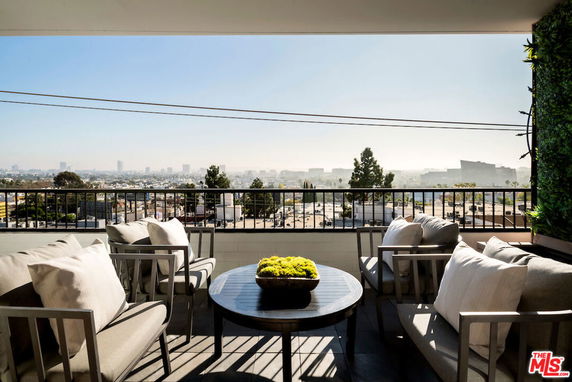 A terrace with seating offering a panoramic view of the city skyline.