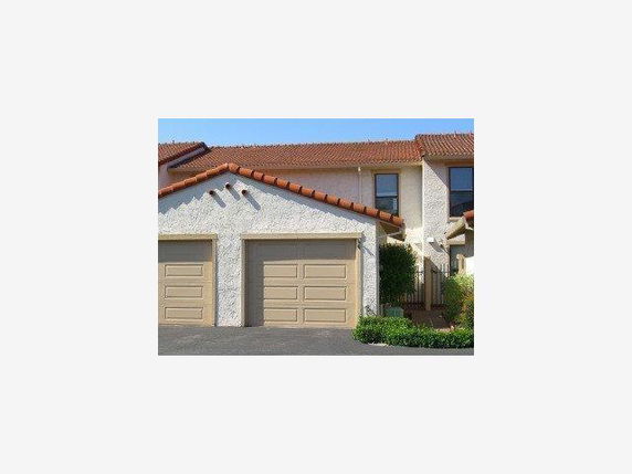 Front view of a house with two garages and a gable roof.