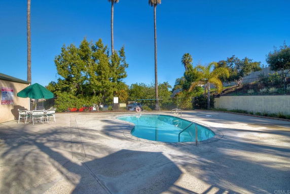 Outdoor swimming pool with surrounding patio and trees.