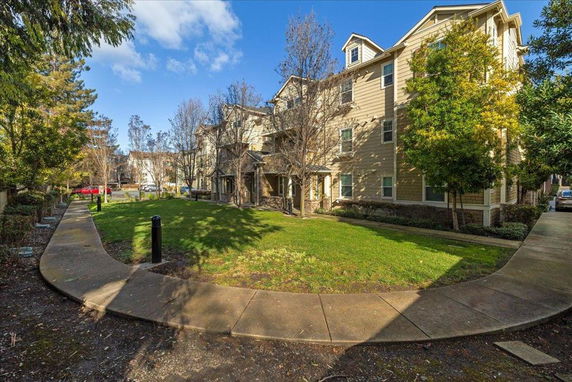 Front view of a multi-story residential building with a landscaped garden area.