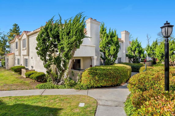 Front view of a two-story apartment building with a sloped roof and multiple windows.