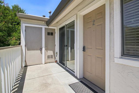 Front view of an entrance area with two doors and a railing on a building.