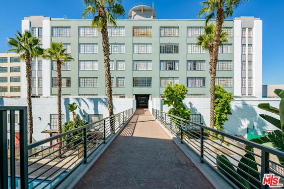 Front view of a multi-story building with a walkway leading to it.