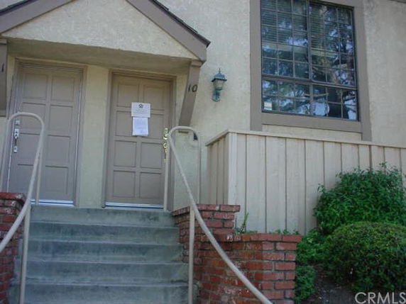 Front view of a house with two doors and steps leading up.