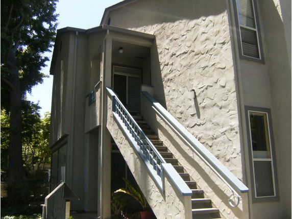 Front view of a two-story house with an external staircase.