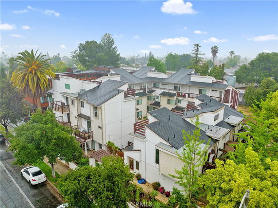 Aerial view of a multi-story residential building complex with multiple balconies and pitched roofs.