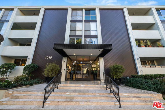 Front view of a multi-story building with entrance steps and balconies.