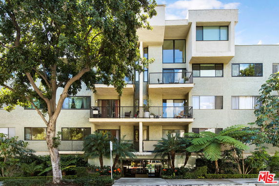 Front view of a multi-story apartment building with balconies.