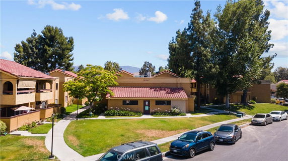Front view of a residential building with red tile roofs.