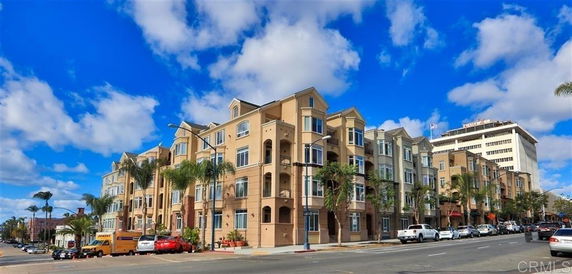 Front view of a multi-story residential building with balconies and multiple windows.
