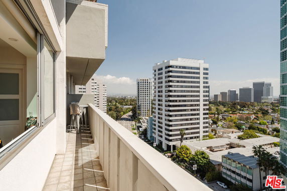View of cityscape from a balcony of a high-rise building.