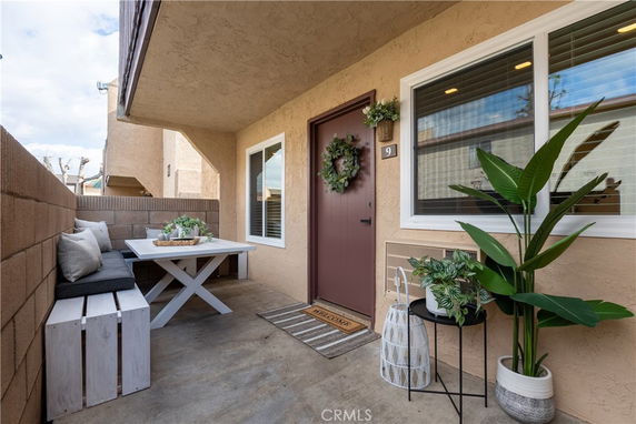 Front view of a house entrance with a covered porch and decorative plants.