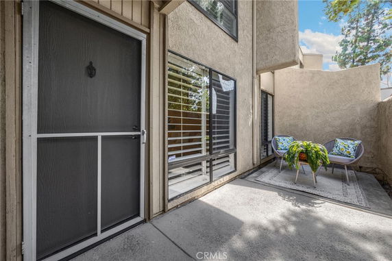 Front view of a house entrance with screened door and patio area.