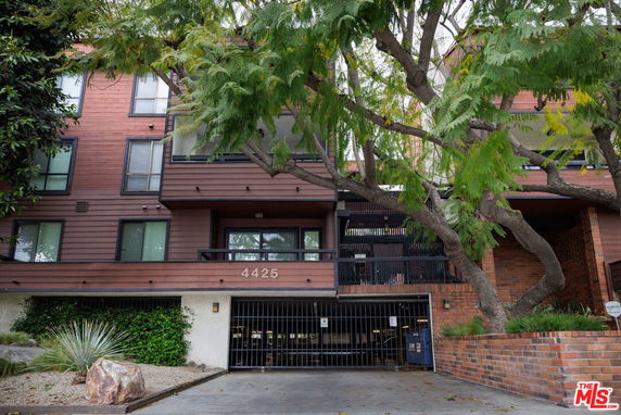 Front view of a multi-story building with a gated entrance.