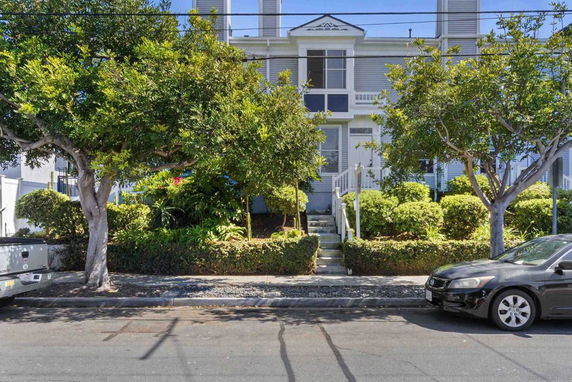 Front view of a two-story house with a symmetrical facade and stairs leading to the entrance.
