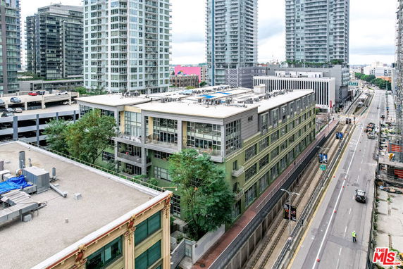 Wide view of a multi-story building surrounded by other tall buildings and city infrastructure.