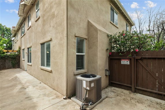 Side view of a two-story house with multiple windows and an air conditioning unit.