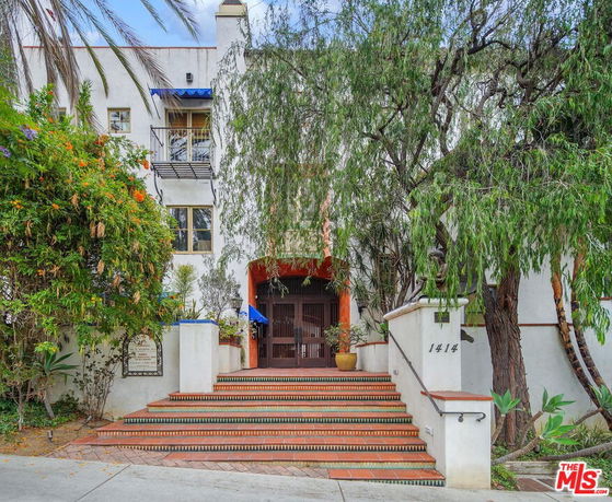 Front view of a multi-story building with a staircase leading to the entrance.