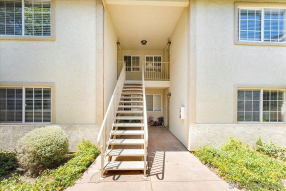 Front view of a two-story building with stairs leading to an upper-floor entrance.