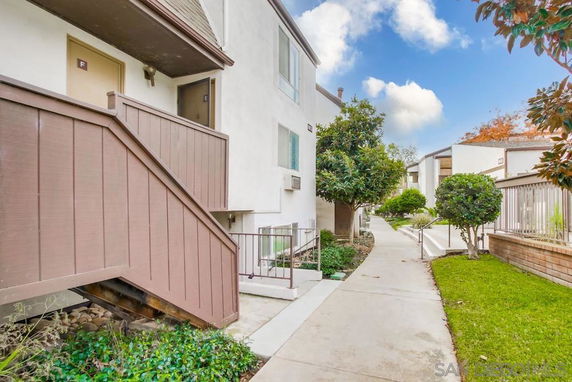 Exterior view of a multi-story apartment building with a walkway.
