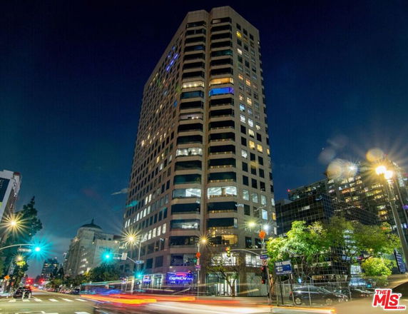 Front view of a tall building illuminated at night.