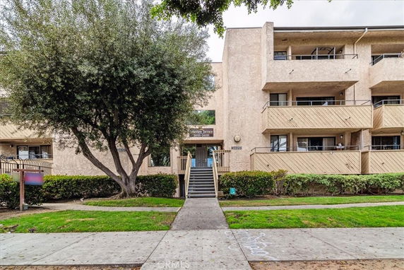 Front view of a multi-story residential building with balconies.