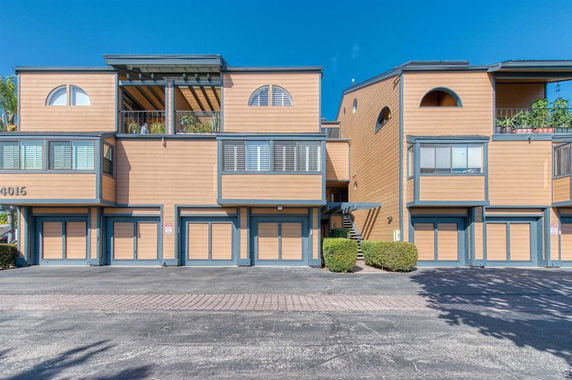 Front view of a multi-story residential building with garage doors.