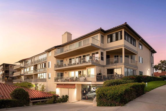 Front view of a multi-story apartment building with balconies.