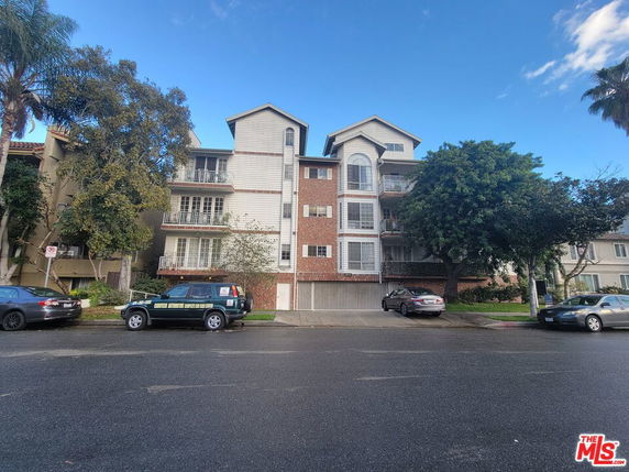 Front view of a multi-story residential building with multiple balconies.