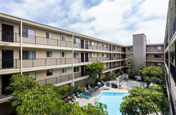 View of a residential building courtyard with a swimming pool in the center.