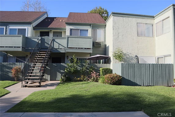Front view of a two-story residential building with an external staircase and balconies.
