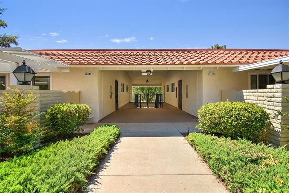 Front view of a house with a tiled roof and open walkway.