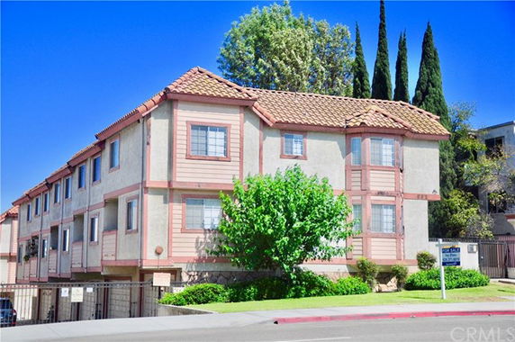 Front view of a multi-story residential building with a tiled roof.
