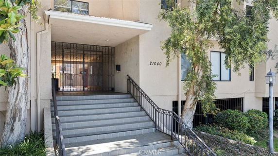Front entrance of a building with stairs and a wrought iron gate.