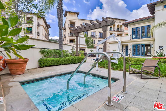 Outdoor view of a residential area with a small swimming pool and patio furniture.
