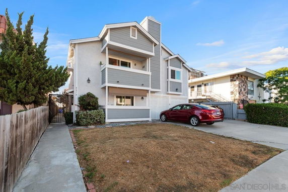 Front view of a multi-story house with attached garages and balconies.