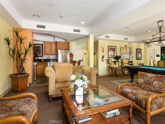 Recreational room with seating area, pool table, and kitchen facilities.