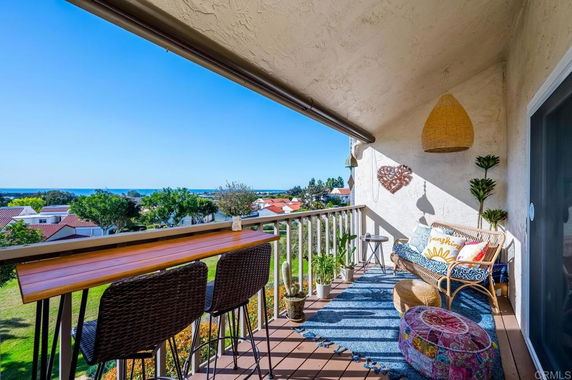 Balcony view with seating and a scenic landscape in the background.