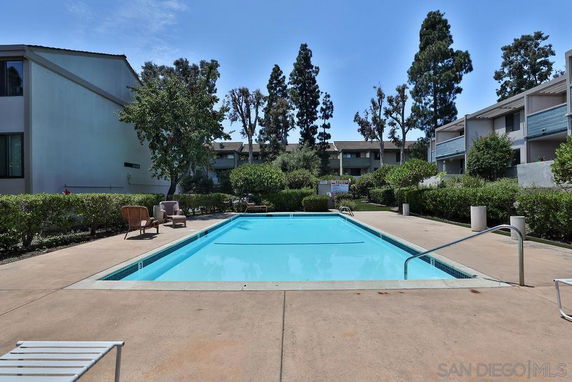 Outdoor swimming pool area surrounded by residential buildings.