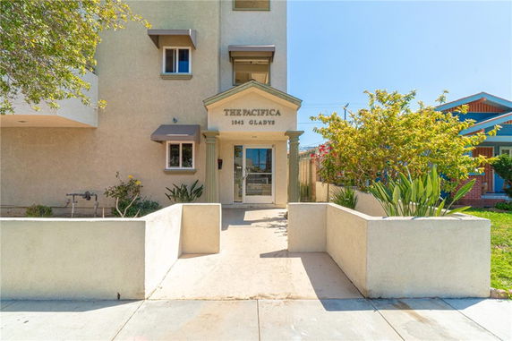 Front view of a building entrance with signage 'The Pacifica 1043 Gladys'.