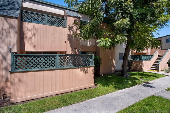 Front view of a two-story building with wooden paneling and lattice fencing.