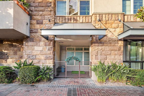 Front view of a building entrance with stone facade and metal gate.