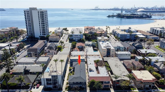 Aerial view of residential area near the beach with various buildings and a visible coastline.